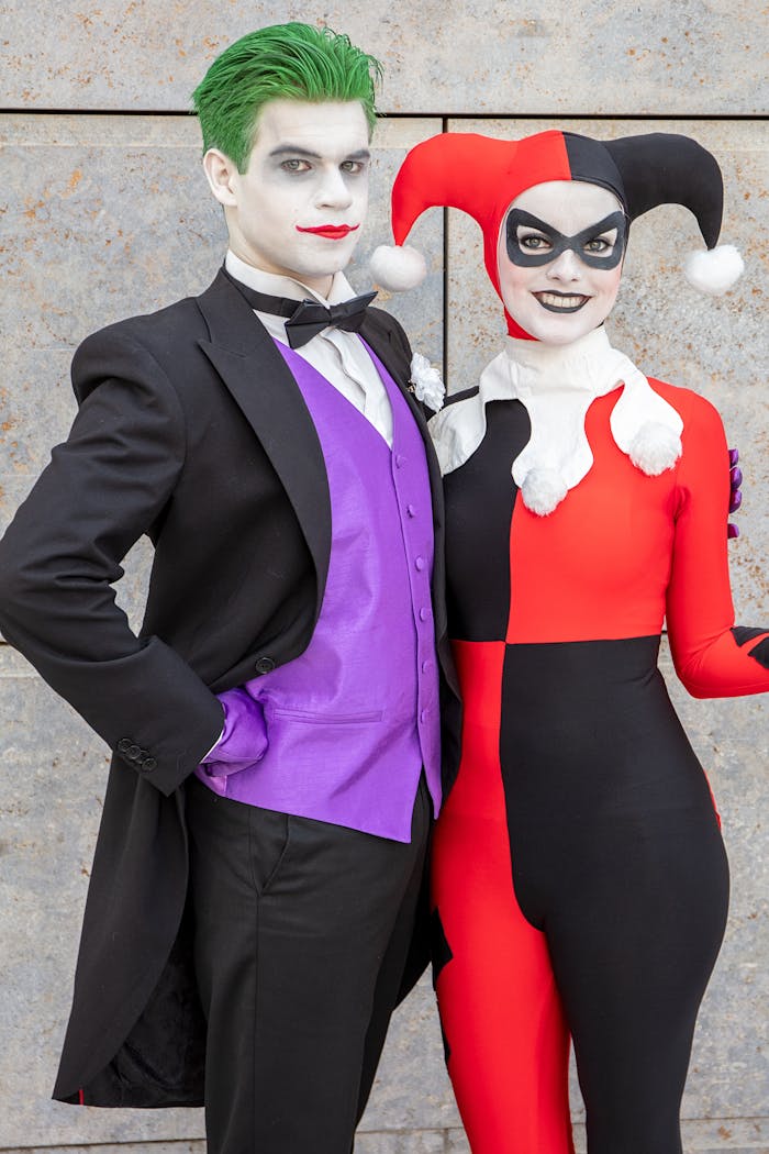Cosplayers dressed as Joker and Harley Quinn pose together, showcasing vivid costumes and makeup.